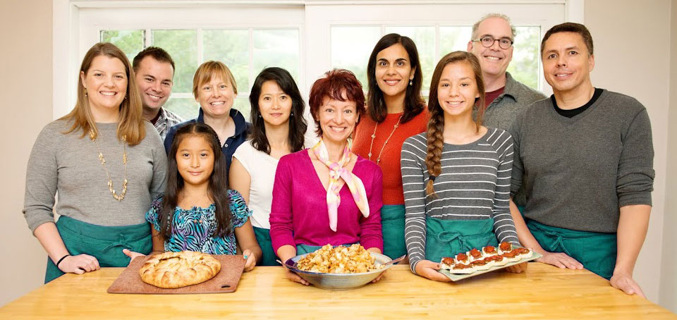 Smiling participants in a cooking class at Helen's Kitchen.